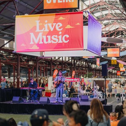 Crowds watching live music on stage in a shed.
