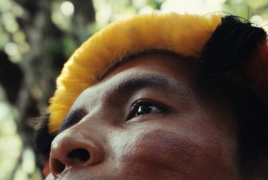A close up of part of an Indigenous man's face in an outdoor setting.