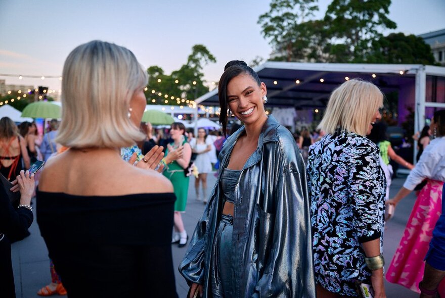 People smiling and socializing at Museum Plaza, the hub of the Melbourne Fashion Festival. 