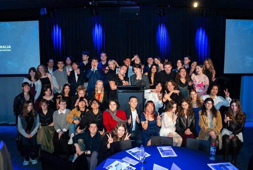 A large group of attendees gathering on stage at the Australia Youth Film Festival ceremony.