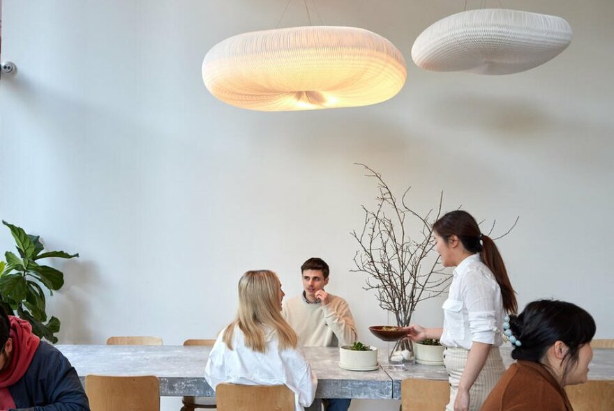 A couple sitting at a table at a minimalist white cafe