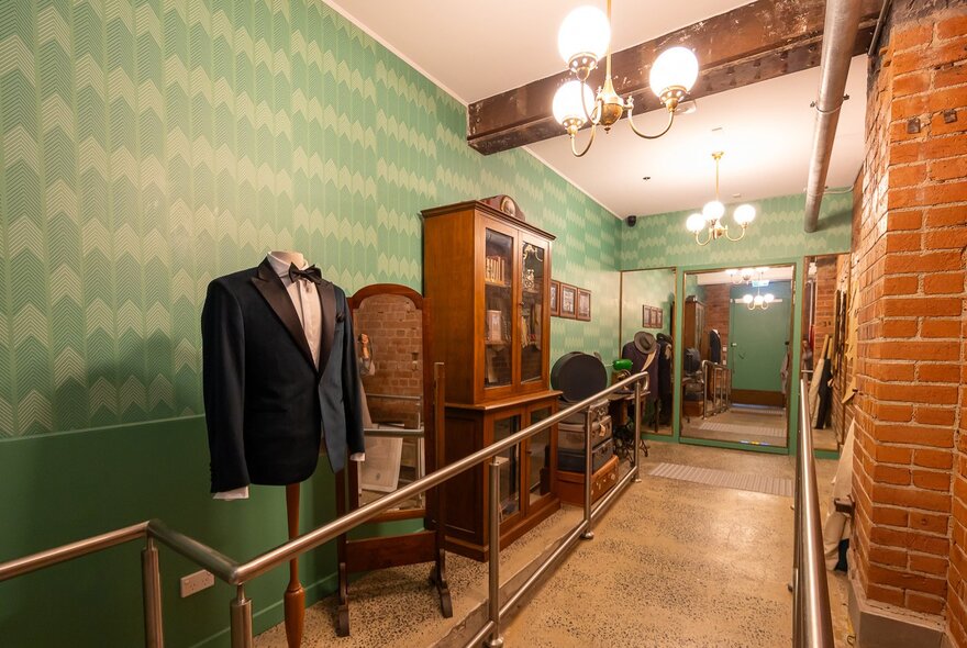A hallway with old sewing shop details including a suit on a mannequin and an old wardrobe.
