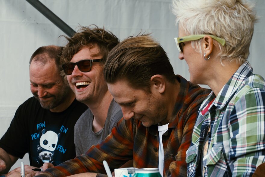 The four members of the Australian rock band Jebediah, seated in a row, wearing casual clothes.