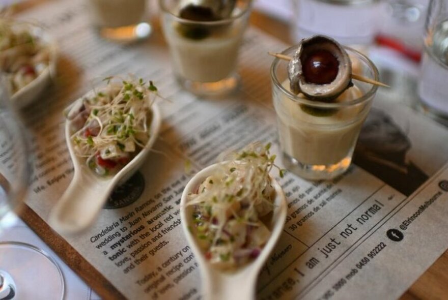 Shot glasses and spoons filled with Spanish tapas.