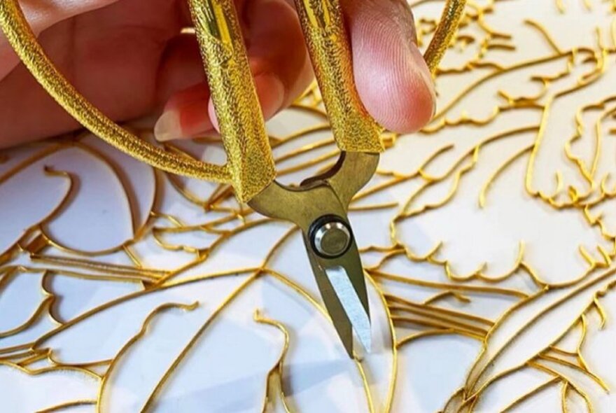 Tweezers working with wire frames to create enamelware.