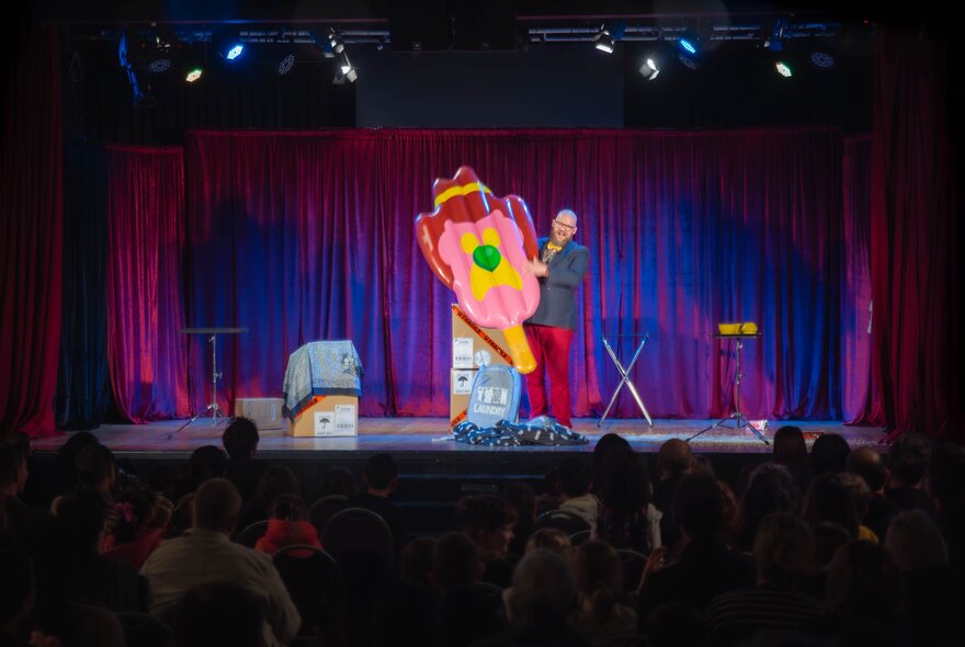 A performer on stage with a large inflatable Bubble o' Bill. 