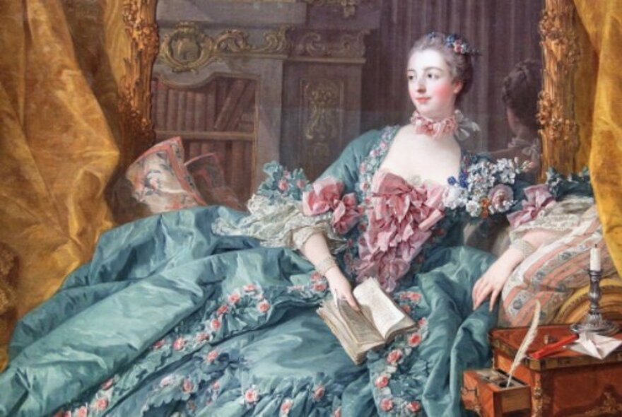 Painting of Madame de Pompadour reclining wearing a lavish blue and pink gown, holding a book.