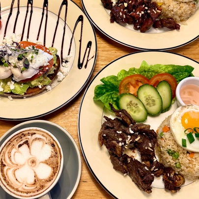 Filipino breakfast dishes of food includig rice and eggs, with cappuccino.