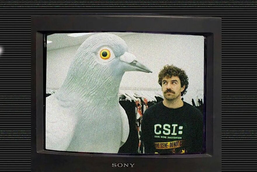TV screen displaying a man in a clothing store looking sideways at a giant sculpture of a white seagull.
