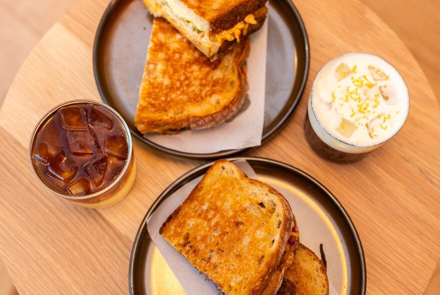 Looking down on a table with plates of toast and iced coffees.