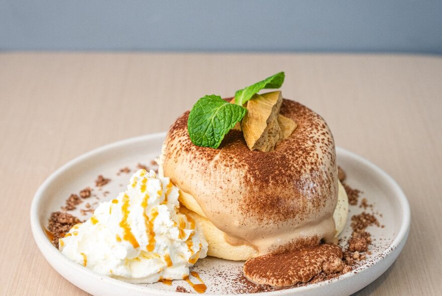 Souffle-style fluffy pancakes with cream and a dusting of cocoa. 