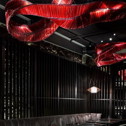 Underground bar with red lighting feature snaking across the ceiling.