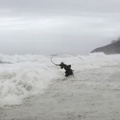 Artist Julius von Bismarck's black and white photographic artwork, Punishment #7, showing a man cracking a whip into the waves at a stormy beach.