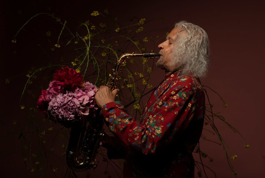 Saxophonist, Gary Bartz, playing the saxophone wearing a vibrantly coloured patterned shit.