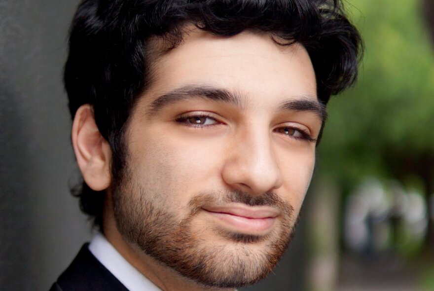 A head shot of classical singer Michael Zuccala, smiling and turning to his right.