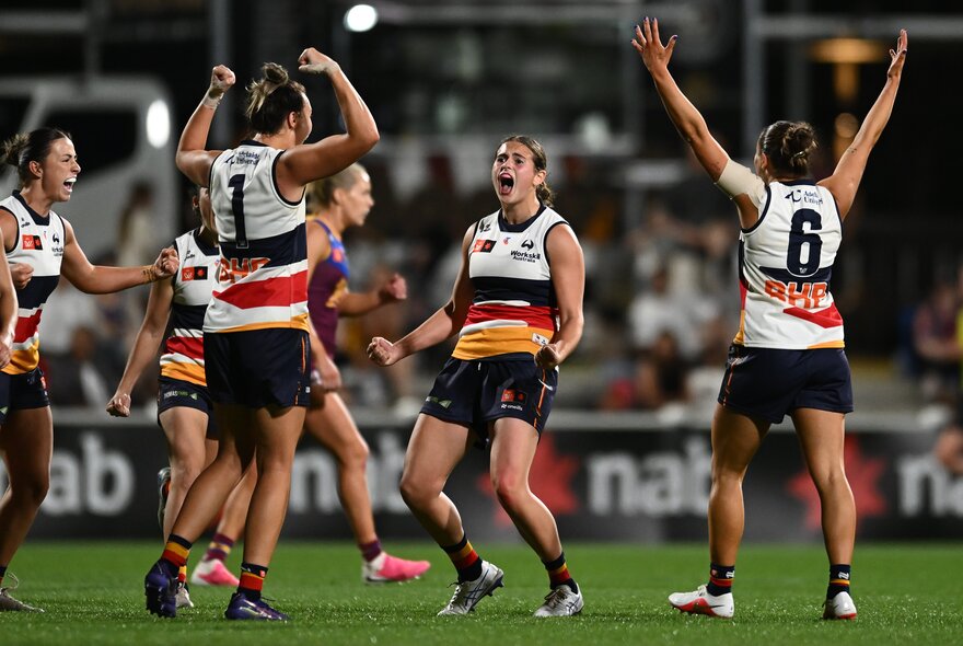 Adelaide Crows AFLW players celebrating on the field.