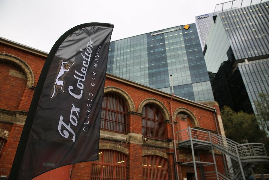 External view of Fox Collection redbrick building with arches, against a glass-walled skyscraper.