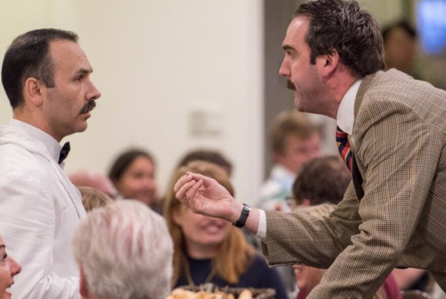 People dressed as characters from Fawlty Towers at a dinner. 