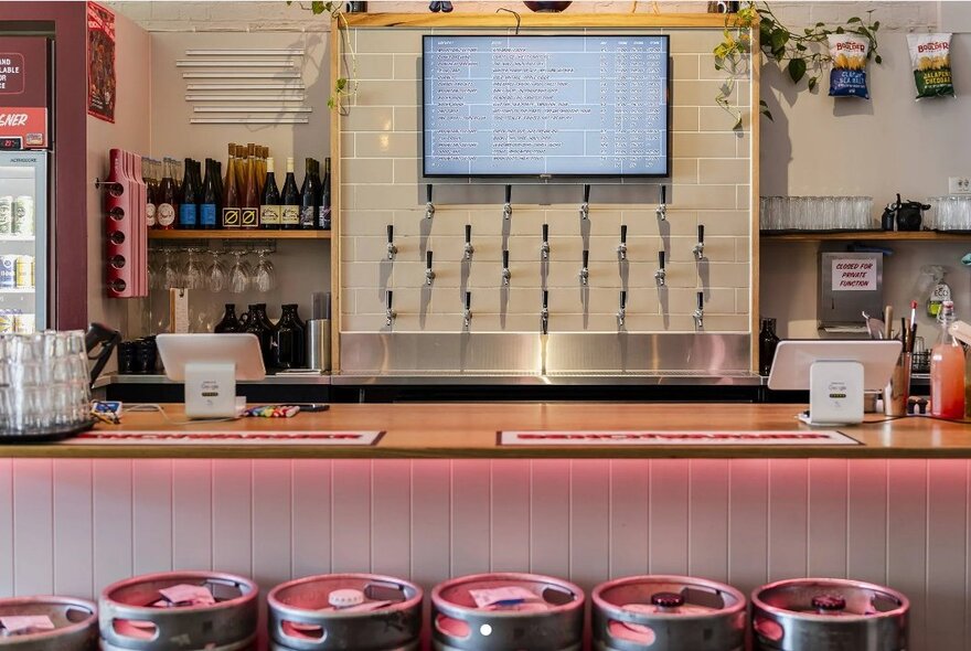The interior of a craft brewery, with multiple beer taps on the rear wall.
