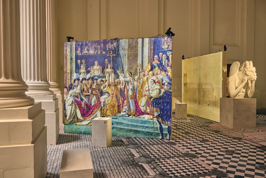 A large print of a colourful painting depicting the crowning of a monarch, inside a large room with checked carpet and marble pillars.