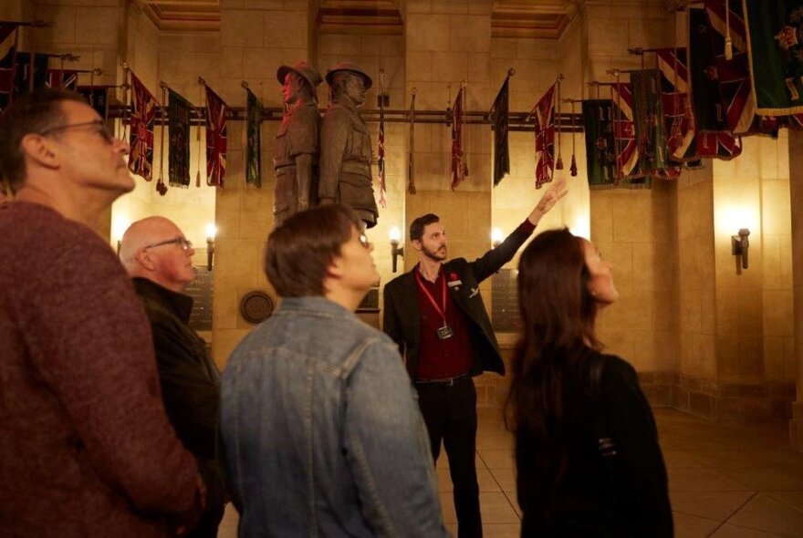 A group of people listening to a guide speaking inside the Shrine.