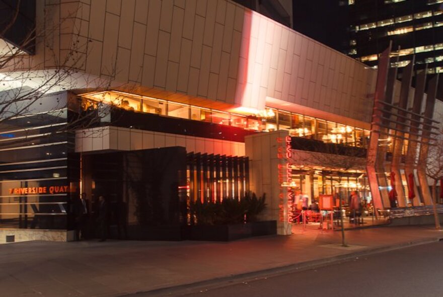 The lit up exterior of the Belgian Beer Cafe at night.
