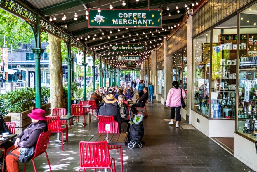 Outdoor diners under fairy lights outside Queen Victoria Market's street traders.