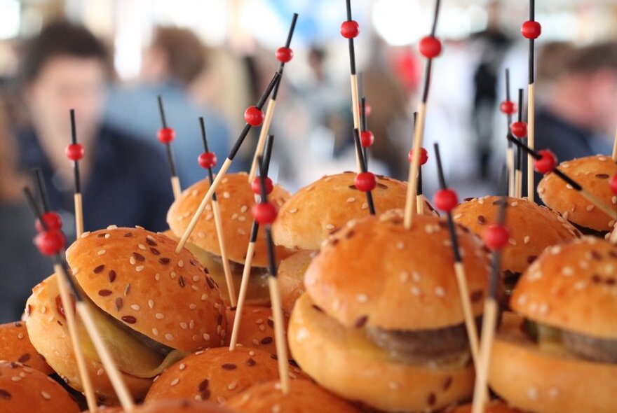 Close up of a plate of small burgers.