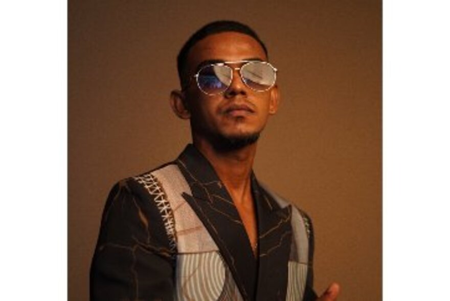 Performer wearing sunglasses and a patterned coat.
