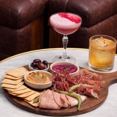 A charcuterie board and two cocktails