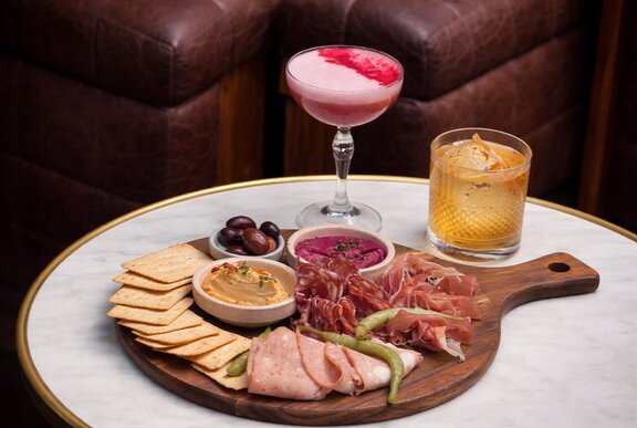 A charcuterie board and two cocktails