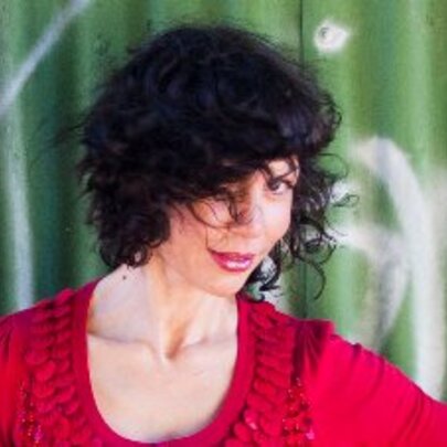 Sultry singer Jackie Bornstein dressed in red with her dark hair covering one eye.