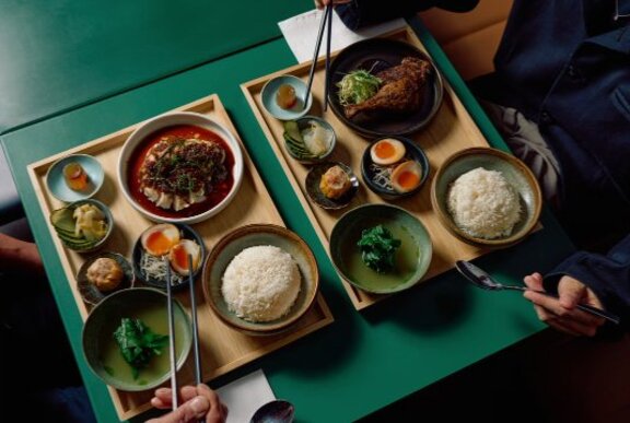 Lunch tray-style Asian meal with multiple bowls of food on a tray.