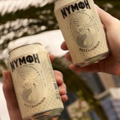 Hands holding cans of Greek beer.
