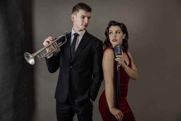Jazz musicians, Lumen Duo, posing with a trumpet and a microphone.