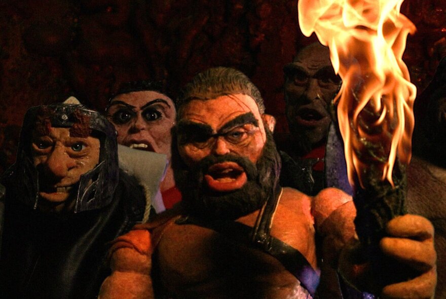 Animated characters with a bearded man holding  fire stick