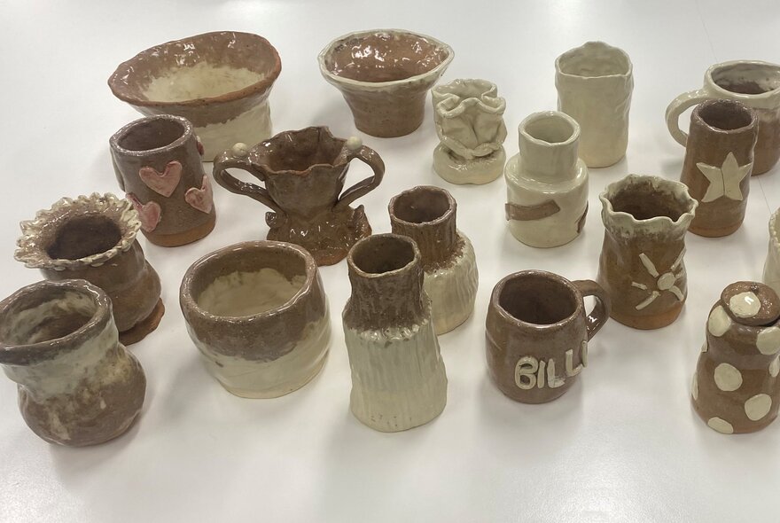 A collection of handmade clay cups and bowls.