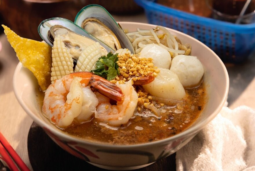 Dish of Asian soup with seafood and bean shoots.