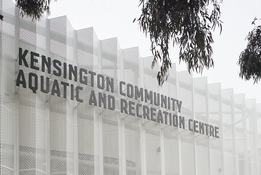 Signage on aquatic centre's white wall.
