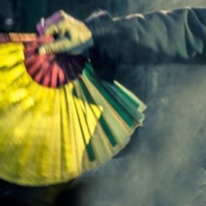 A hand holding an open fan upside-down.