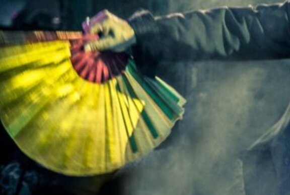 A hand holding an open fan upside-down.