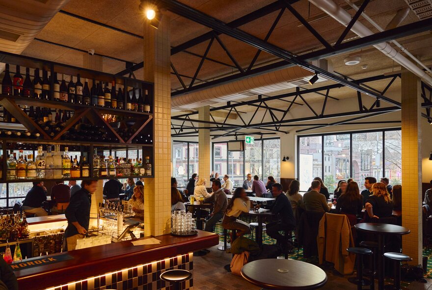 A busy pub with people sitting at bar tables drinking