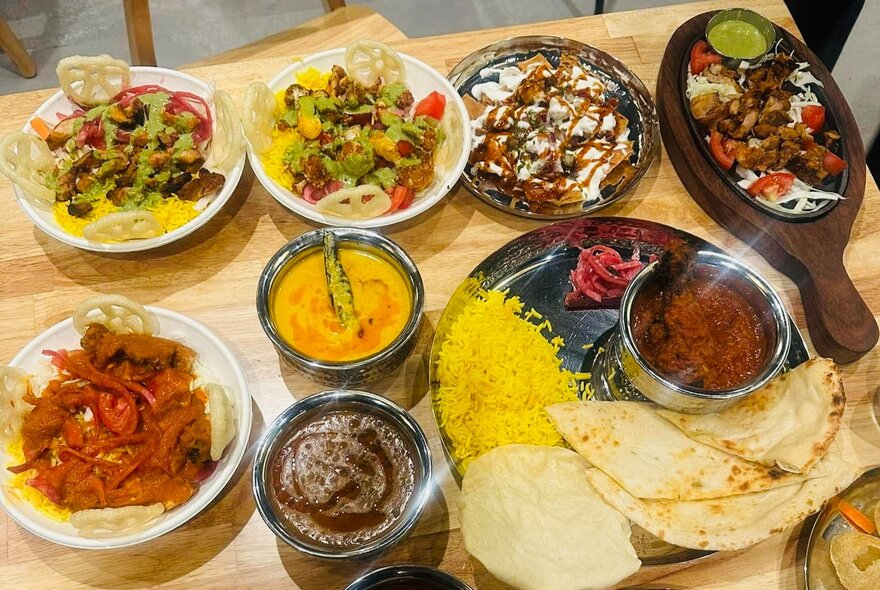 Array of Indian dishes including dahl and rice platter, curries, sauces and rice dishes.