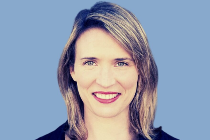 Smiling woman with blonded hair and red lipstick.