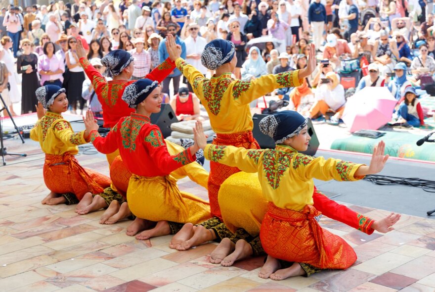An Indonesian cultural dance performance on the stage at Fed Square, with an audience watching from the plaza.