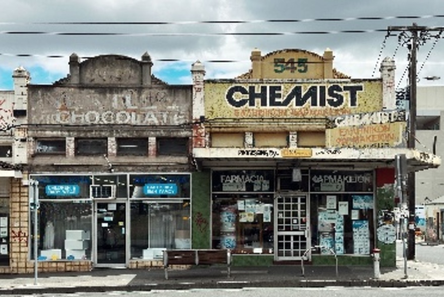 Two old shopfronts, one with a chemist sign above.A 