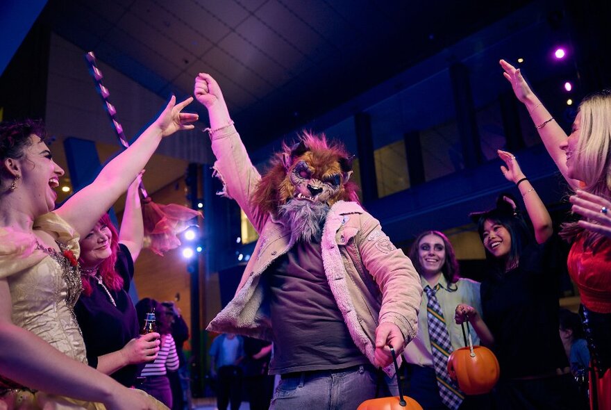 People dressed in Halloween costumes dancing inside the museum.