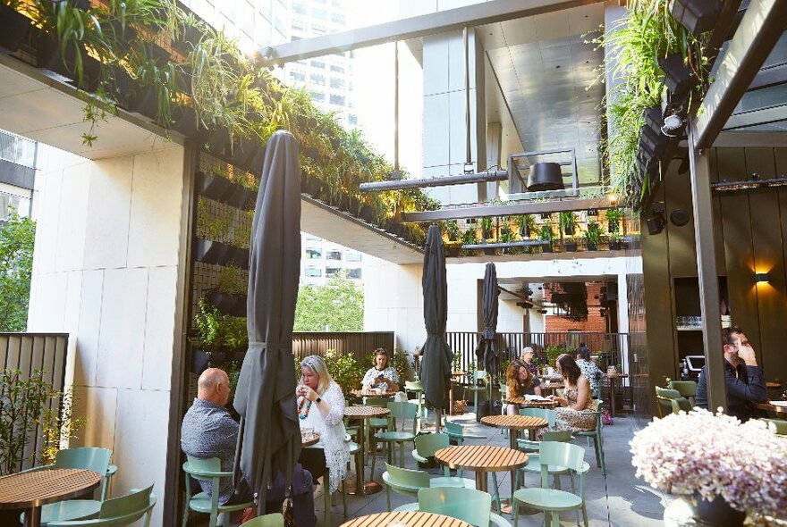 People seated in a large atrium-style section of a restaurant.