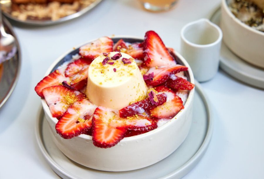 A bowl of strawberries topped with a panna cotta