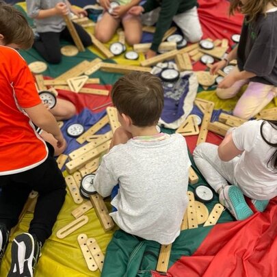 Kids sitting on the floor building with wooden blocks.
